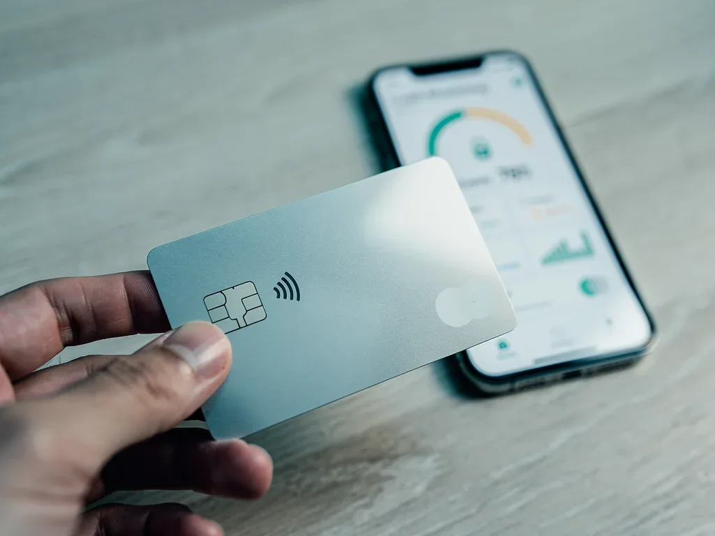 Hand holding secured credit card, credit monitoring app
